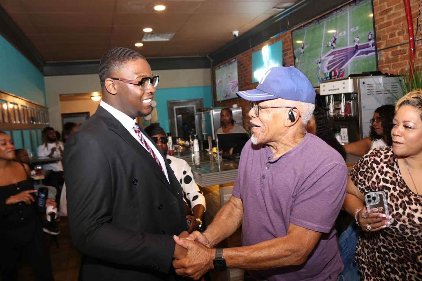 Jayden Williams, a young Black man running for mayor of Stockbridge, Georgia, shakes hands with an elderly supporter