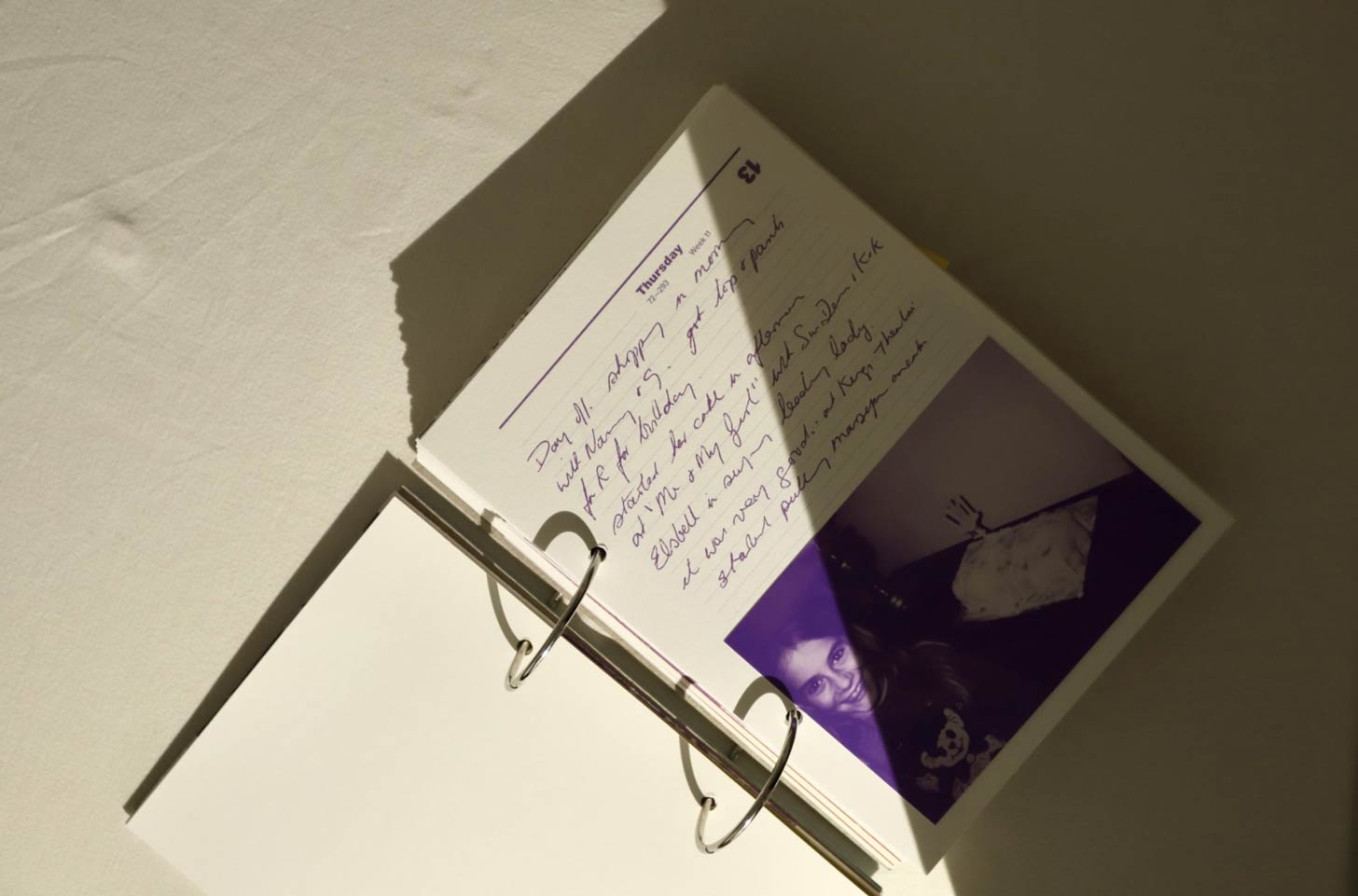A flat-lay of a book with hand-written notes and childhood photos