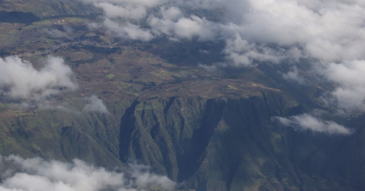 An aerial view of the Great Rift Valley in Ethiopia: a forested mountain shrouded by fog