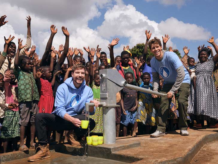 MrBeast and another YouTuber supply clean water from a well and are surrounded by cheering villagers