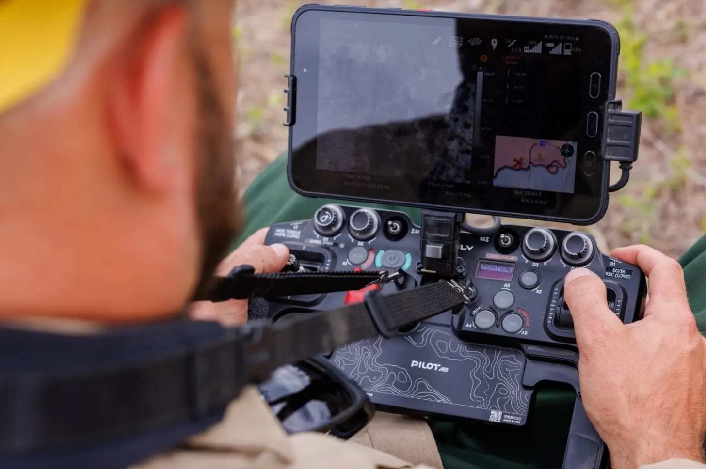 A UAS pilot from the U.S. Forest Service flies a drone using a handheld control system