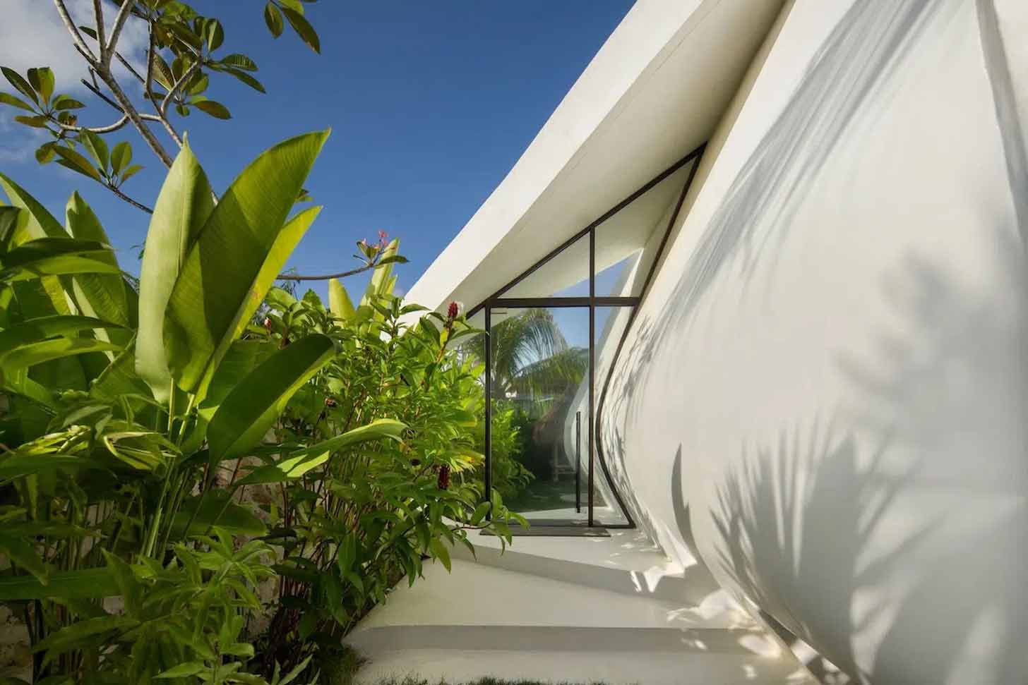 An oddly-shaped door on a pod-like tiny home in Indonesia