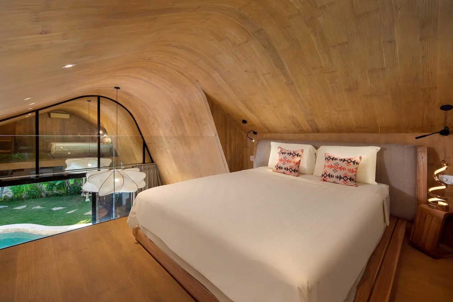 A bed sits inside a wooden mezzanine 