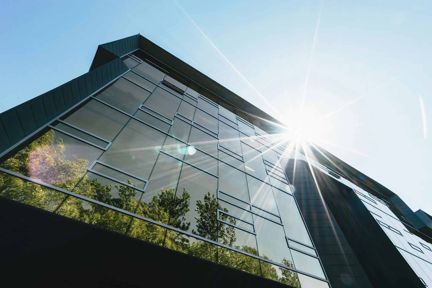 A sun flare refracts off of a building with many windows