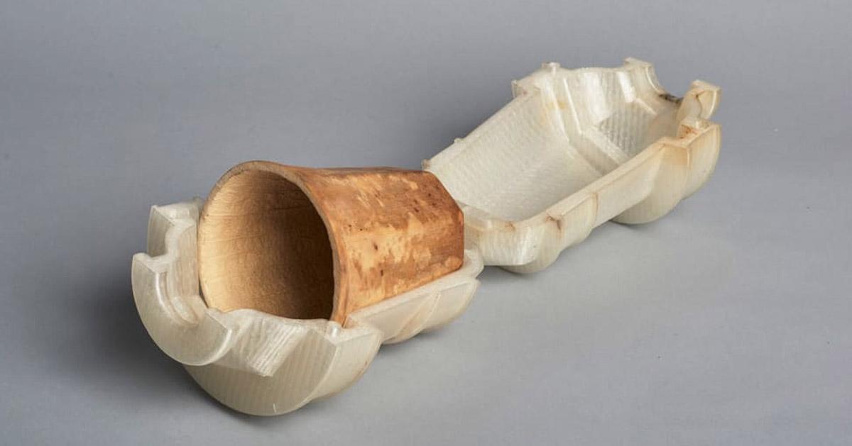 A 3D-printed mold holds a brown cup made from a dried gourd
