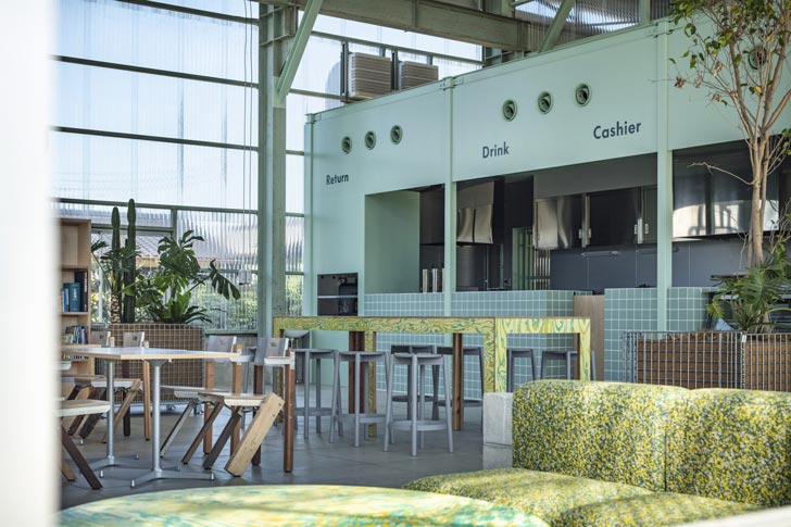 A light-filled cafe with light green walls and colorful furniture