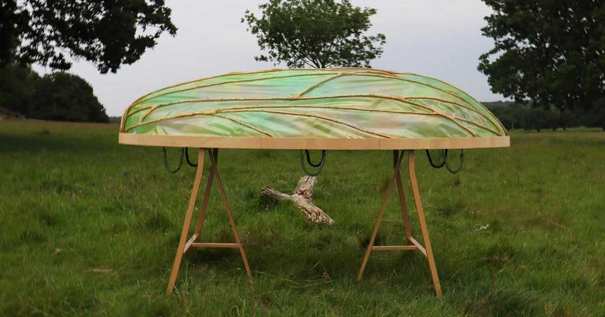 A cocoon-shaped coffin sits atop a wooden base