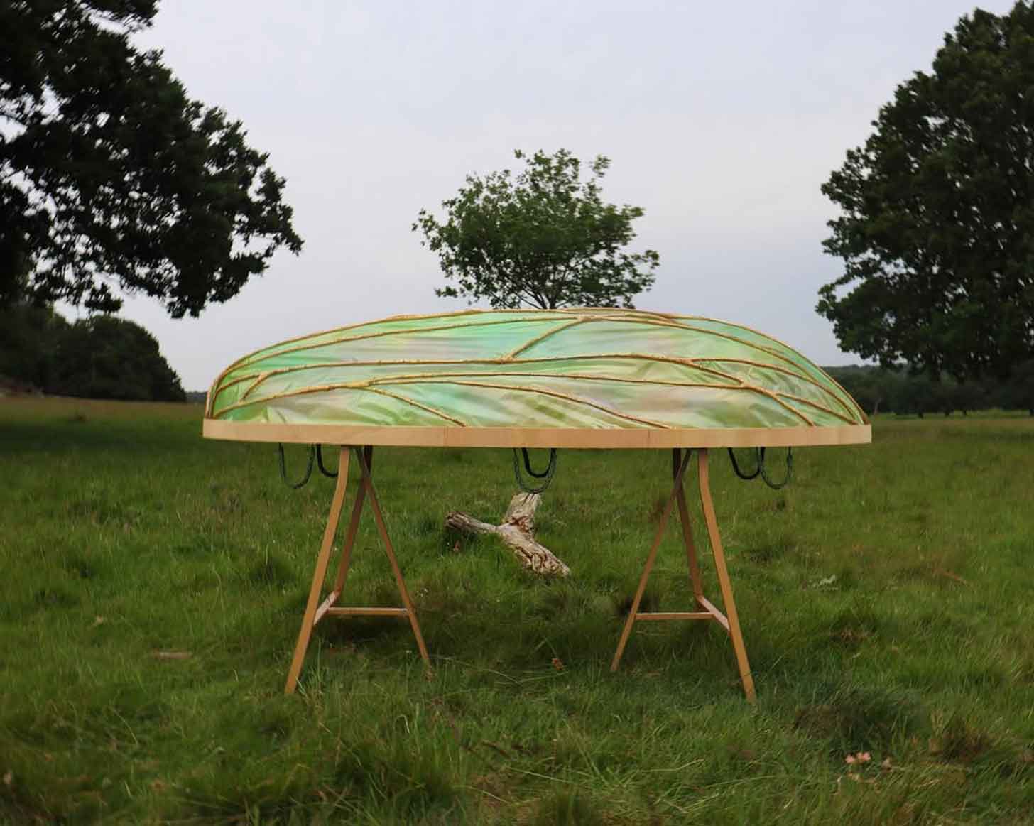 A cocoon-shaped coffin sits atop a wooden base