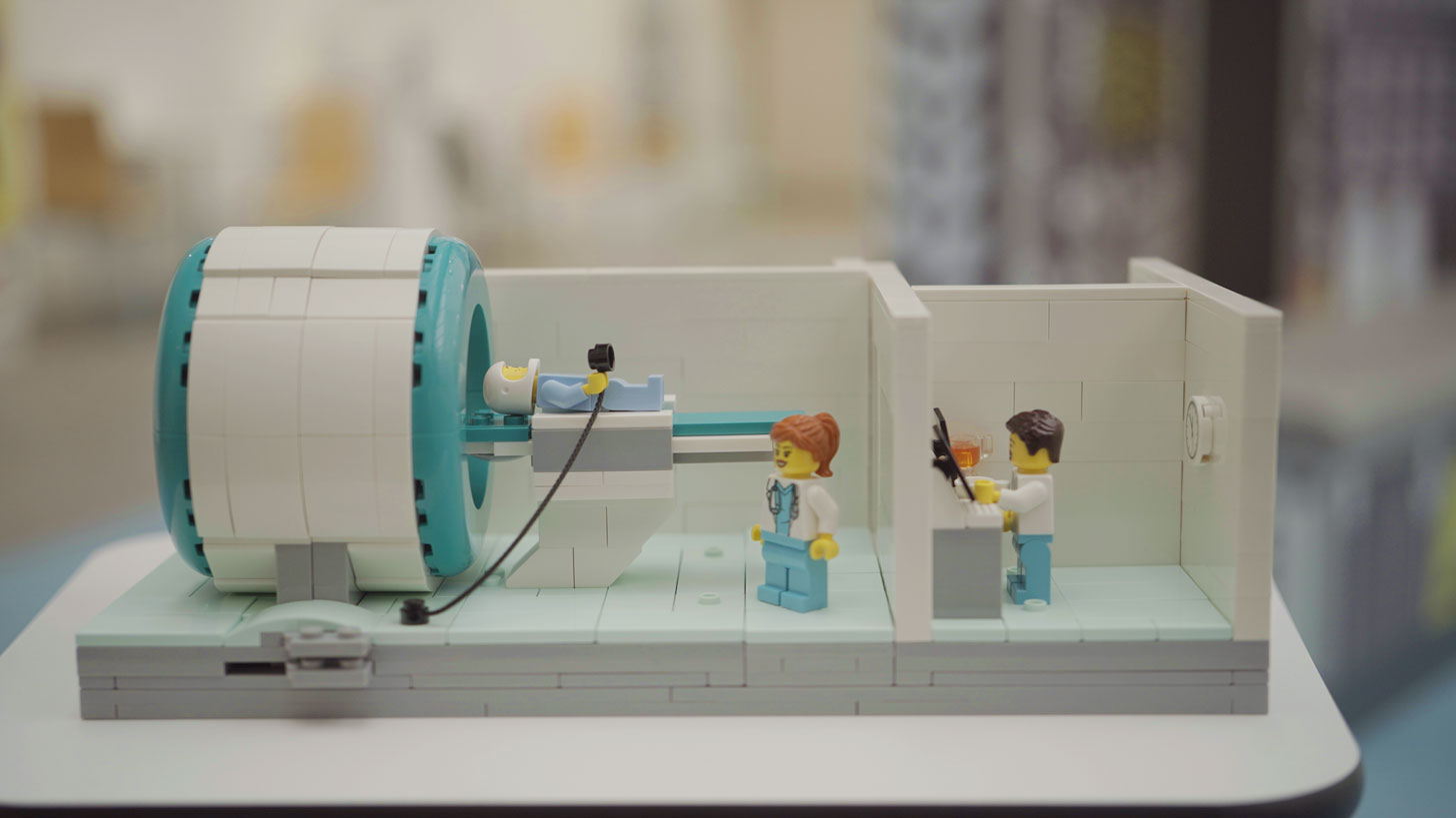 Three LEGO minifigures inside an MRI scene