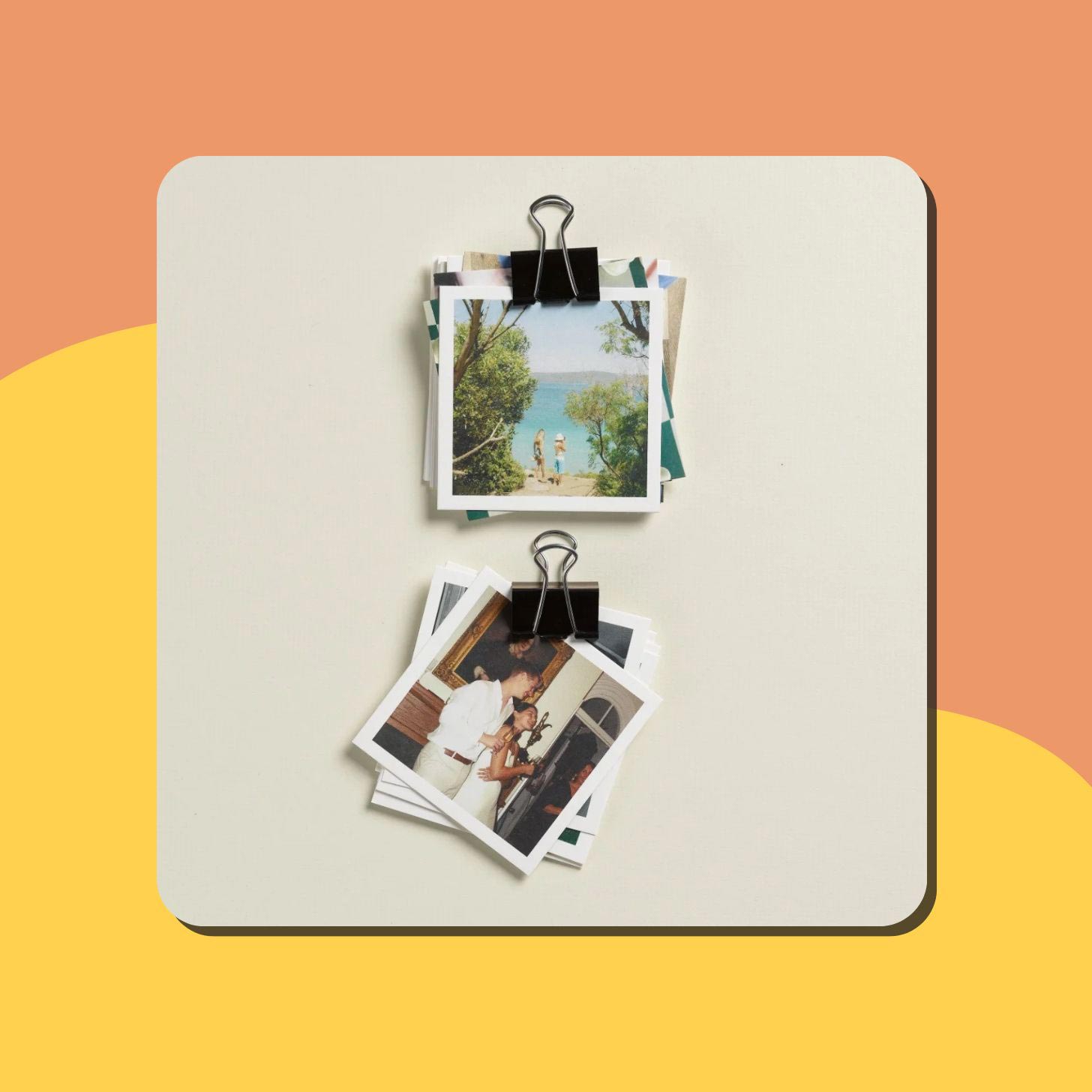A stack of square photo prints held by a black clip