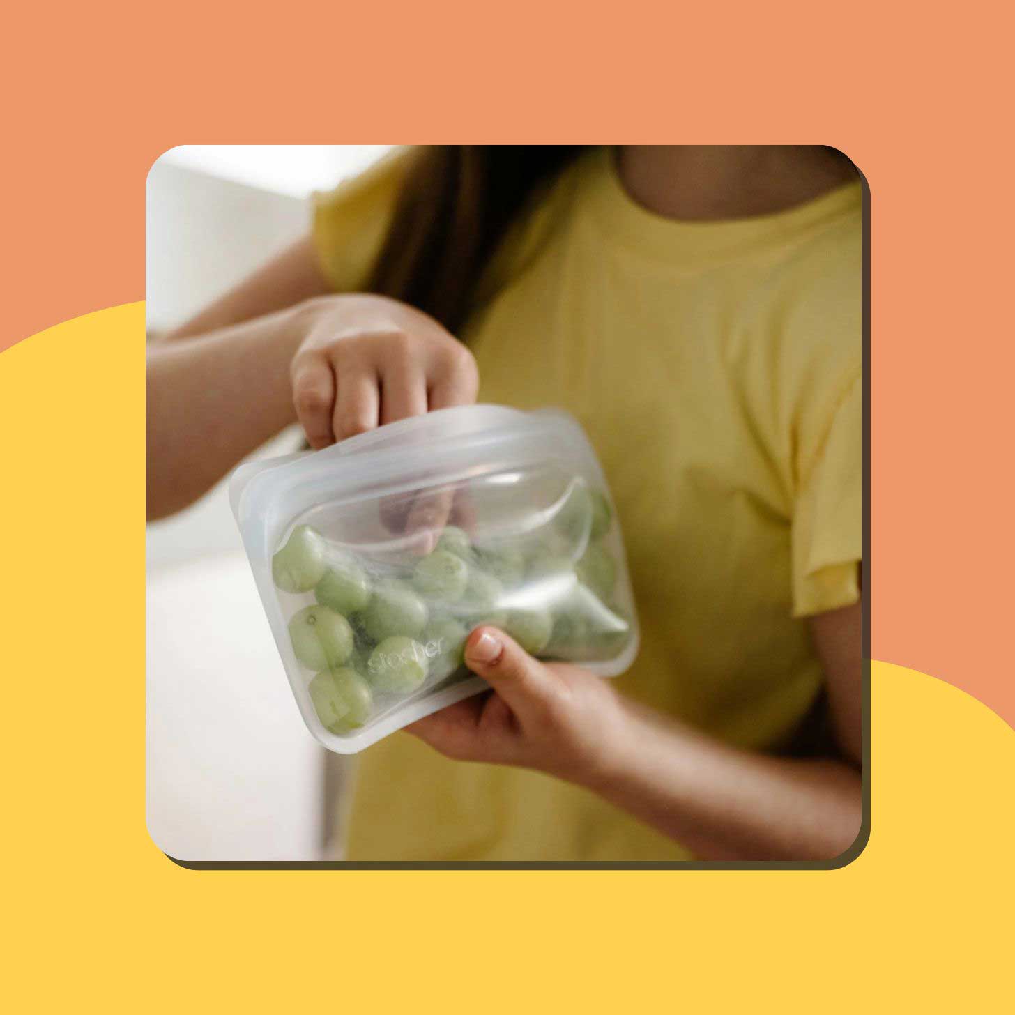 A person holds a clear reusable bag from Stasher