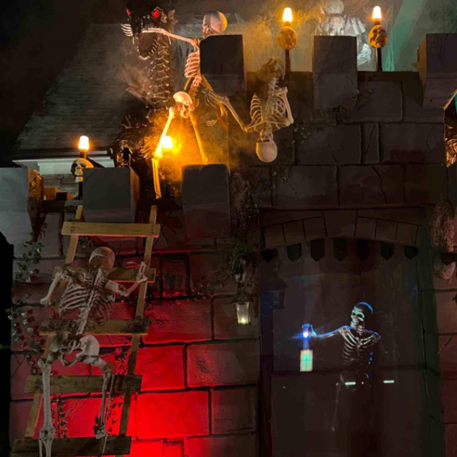 Skeletons climbing over a castle set with firebreathing dragons on top