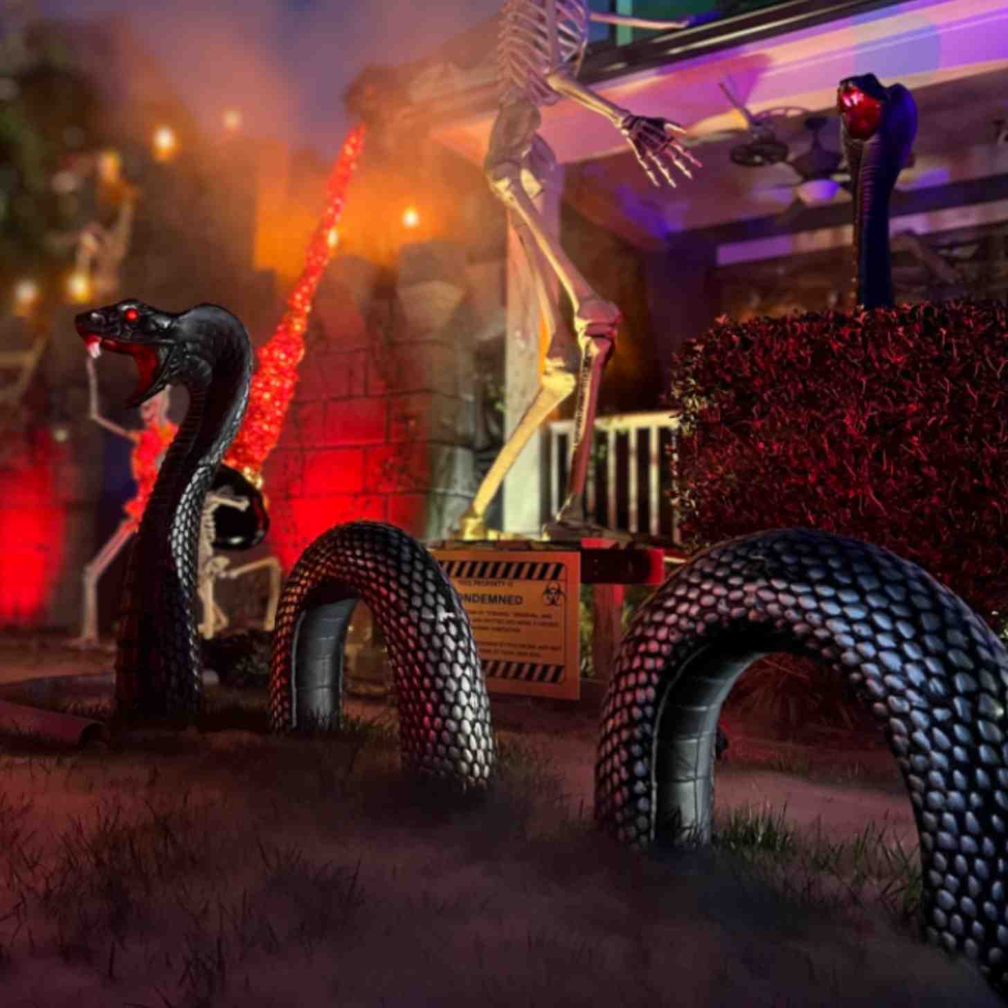 A giant black snake lawn decoration surrounded by large skeletons