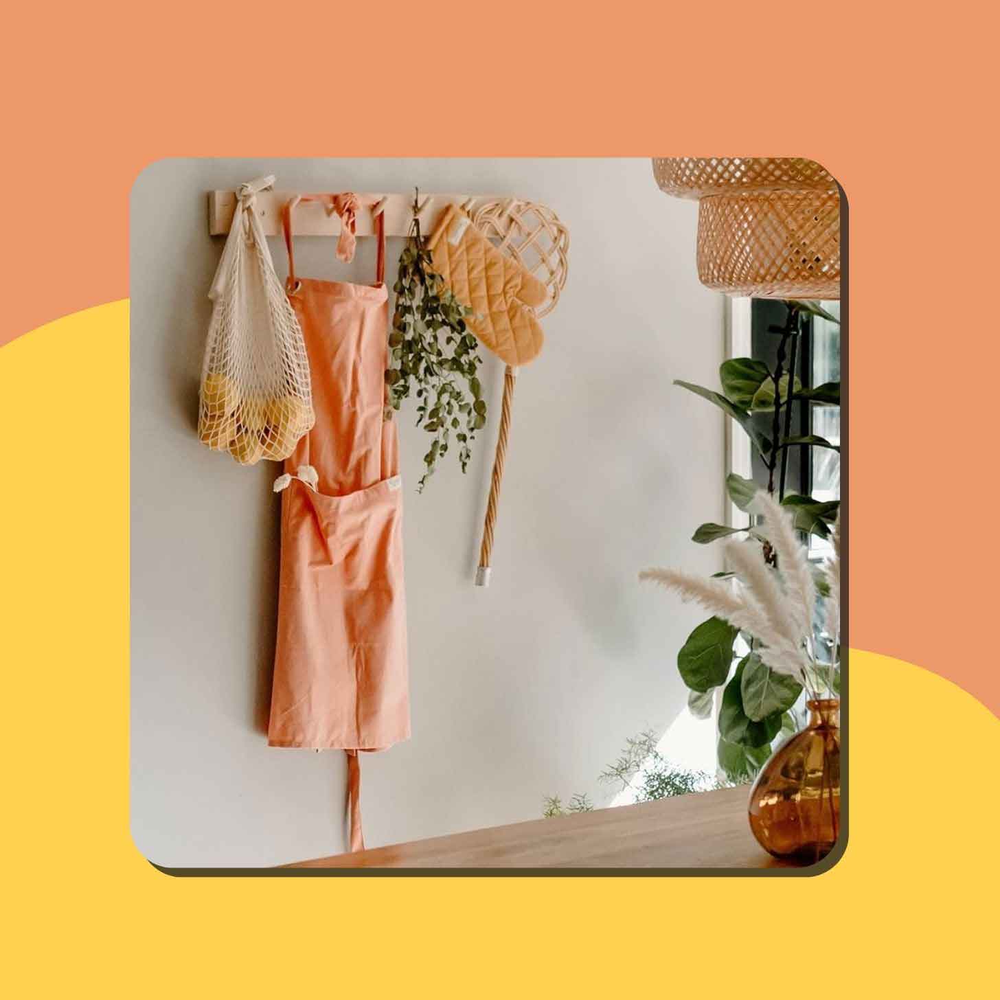 An apron sits on a hook next to plants and a bag of lemons