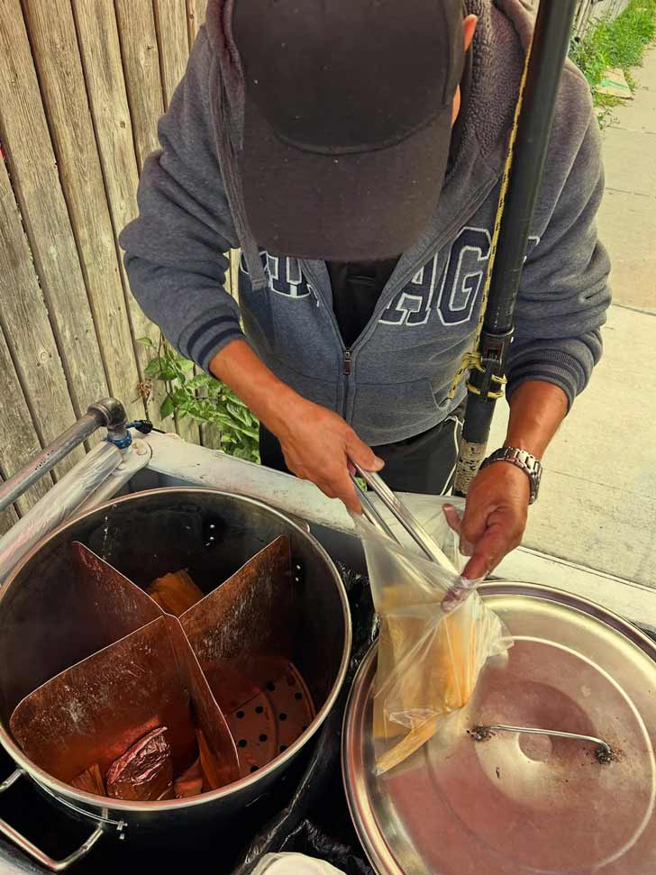 A food cart worker puts tamales in a bag in Chicago