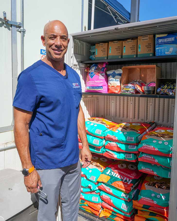 Kwane Stewart smiles in front of a pet food pantry in California