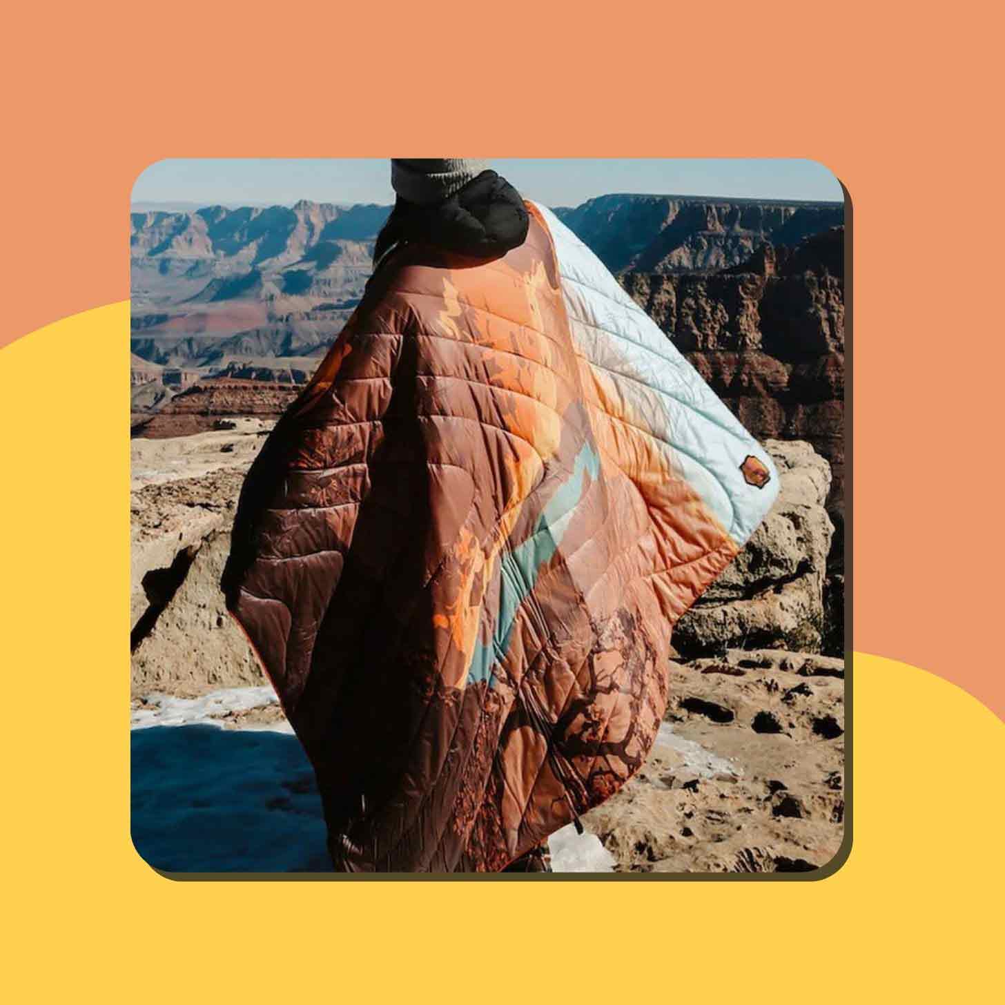 A person wears a puffy camp blanket over their shoulders at the Grand Canyon