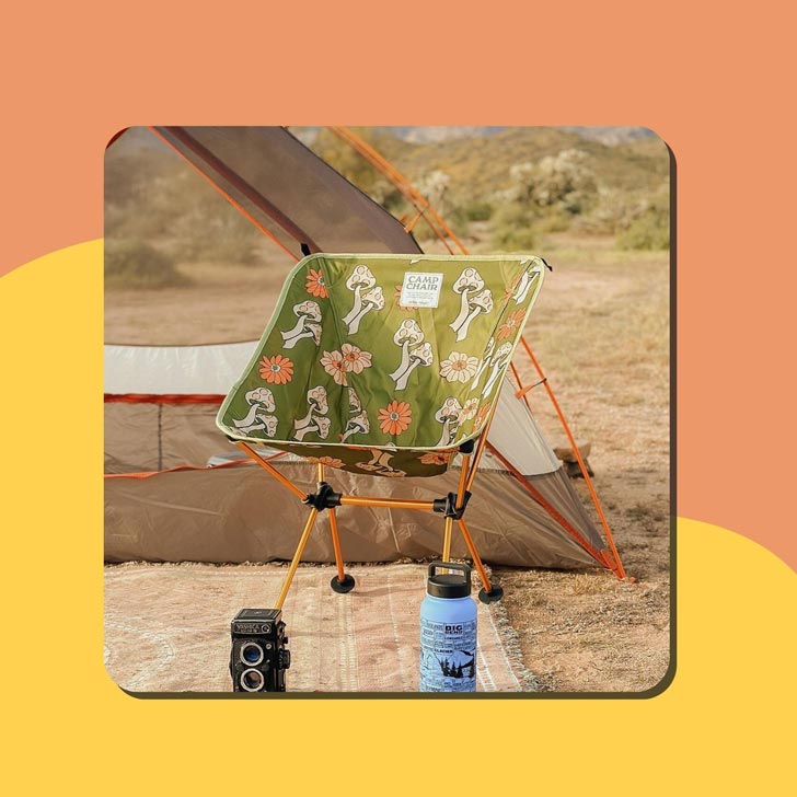 A green camp chair with a mushroom design