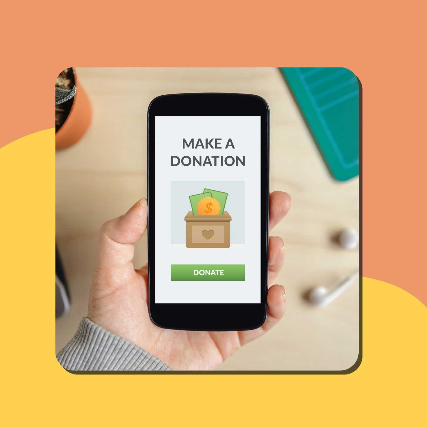 A person holds up a phone screen that reads "make a donation"