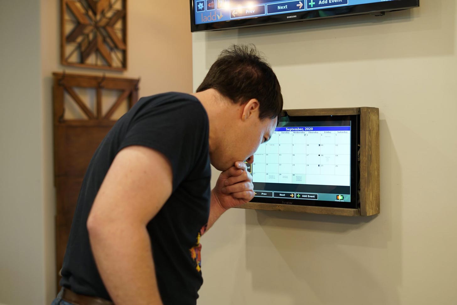 A young man at a smart control panel in a home