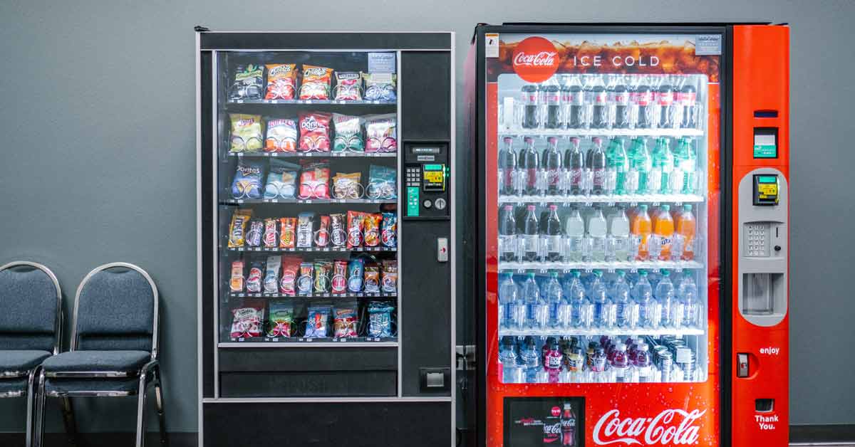 Two vending machines — one with snacks, and another with drinks — sit side by side