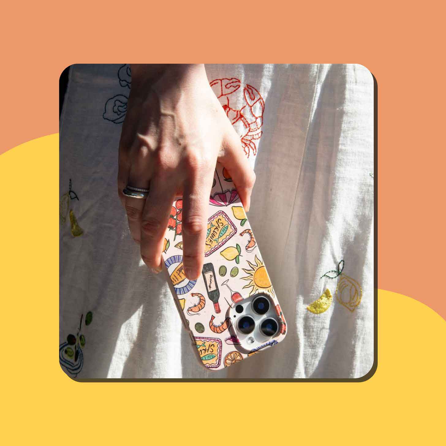 A person holds a Pela compostable phone case