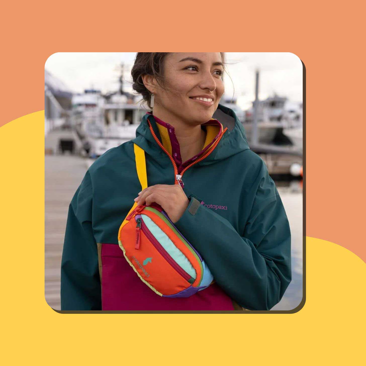 A woman wears a multicolored sling pack from Cotopaxi