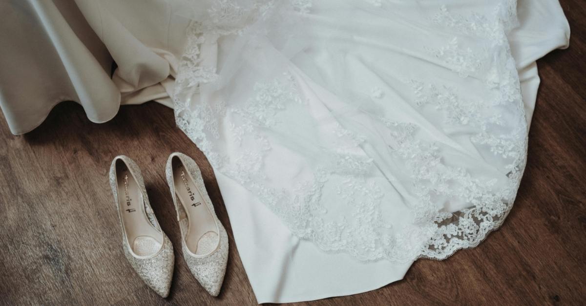 Wedding dress and heels against a wooden floor