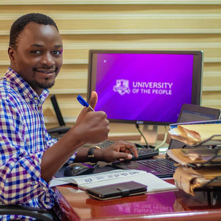 A man holds a thumbs-up beside a computer displaying the University of the People logo