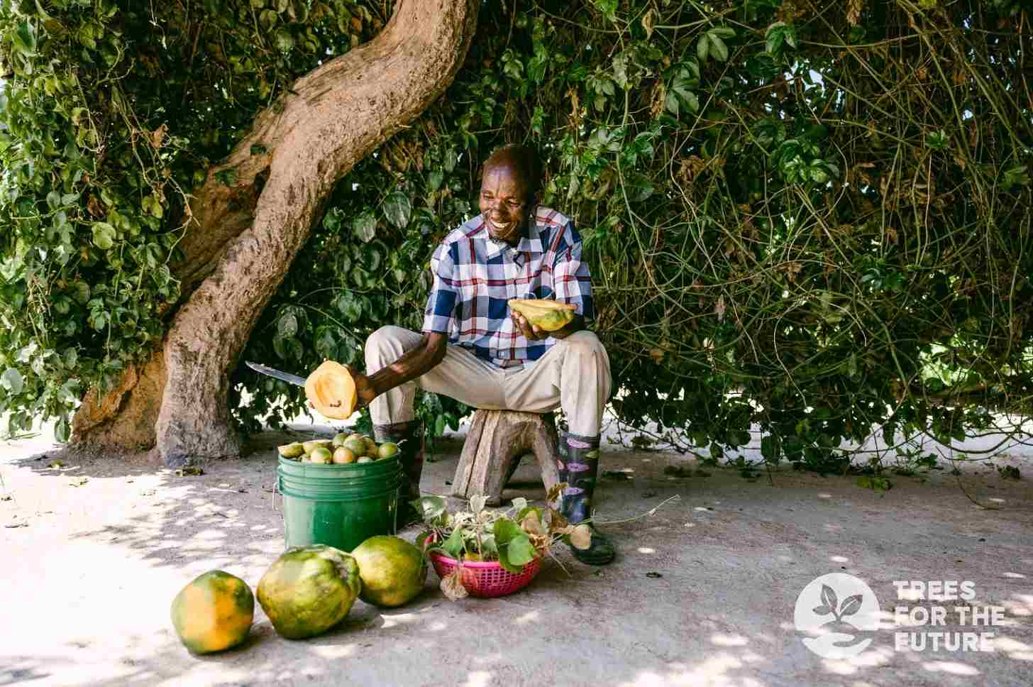 Onesmo, a farmer from Tanzania, with food he has grown from a reforestation project. Image courtesy of TREES.