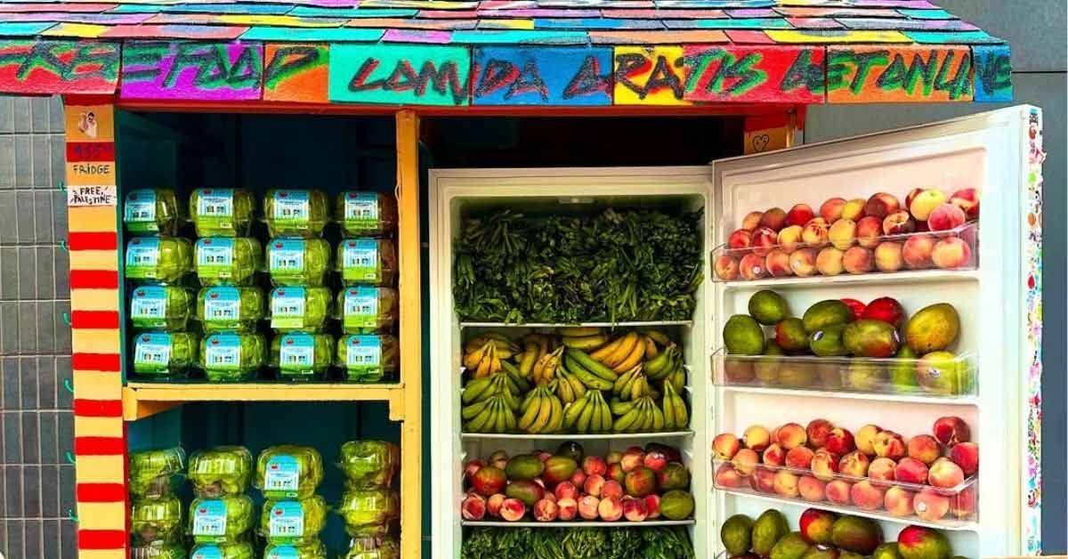 A vibrant community fridge full of lettuce, mangoes, and other produce is open in Harlem, New York