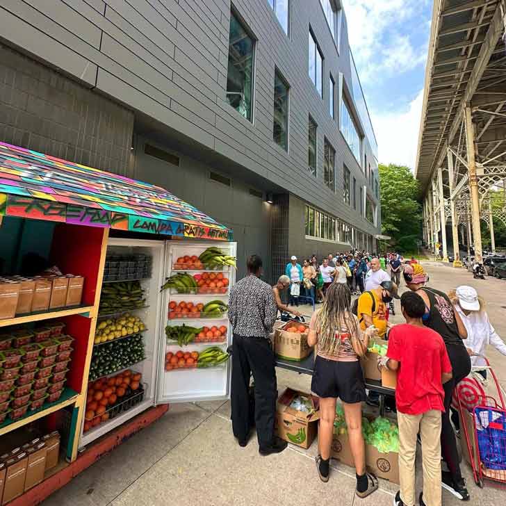 Community members line up for food distribution outside of a free community fridge in harlem