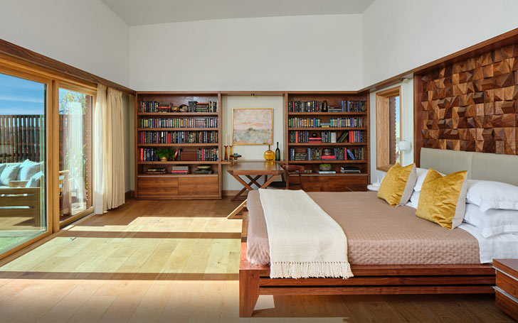A primary bedroom looks out onto a glass door patio