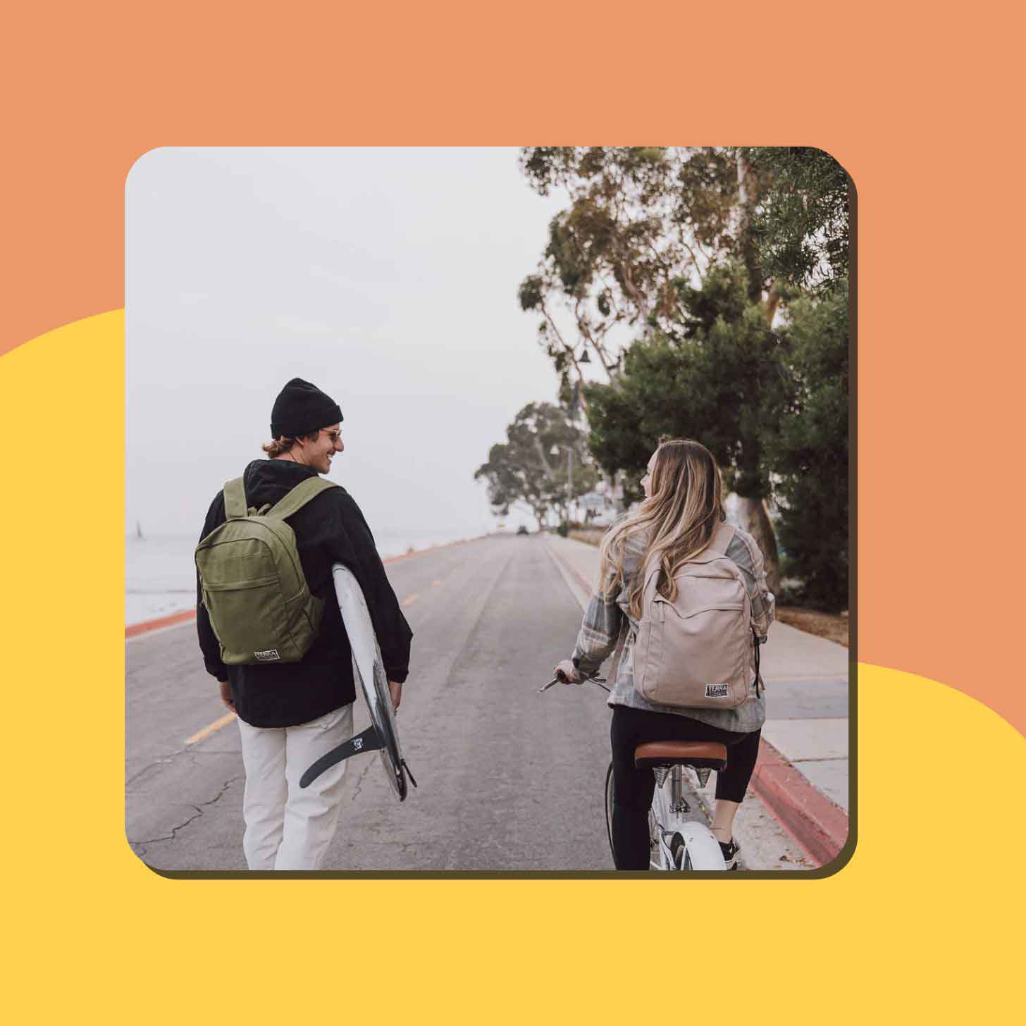 A man and a woman wear Terra Threads backpacks down a quiet street