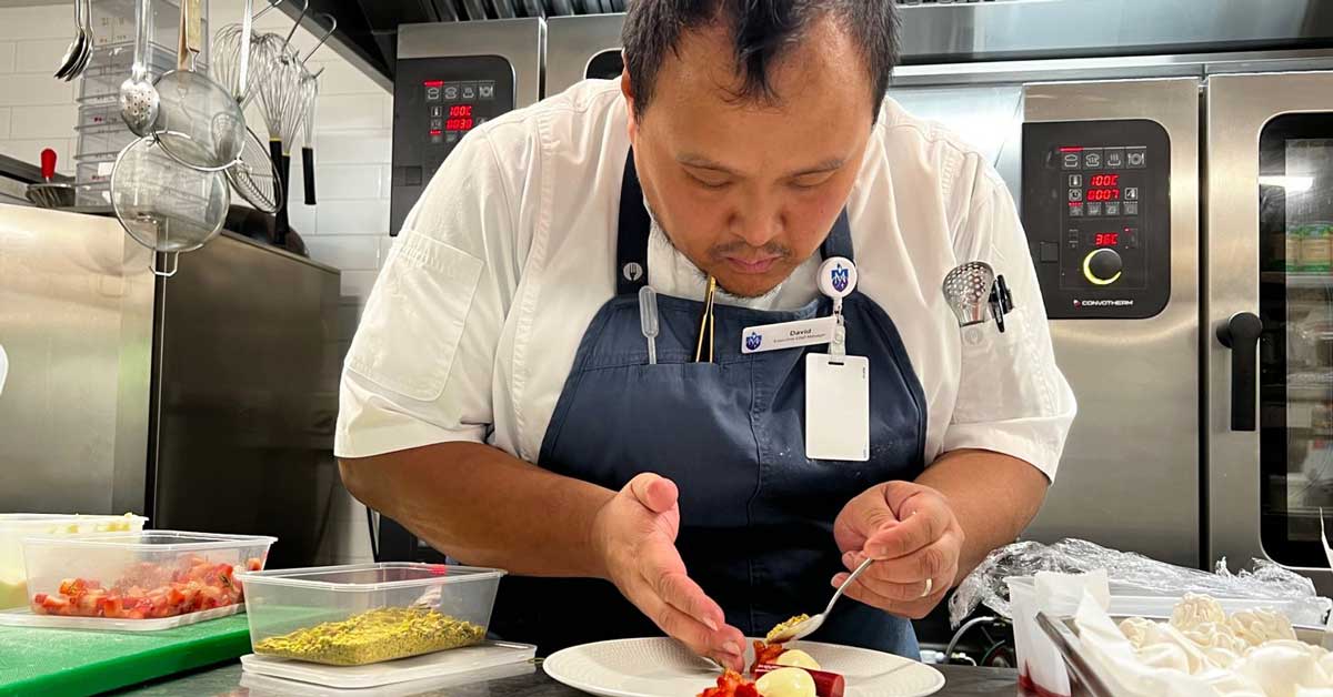Chef David Martin plates a dessert in a commercial kitchen