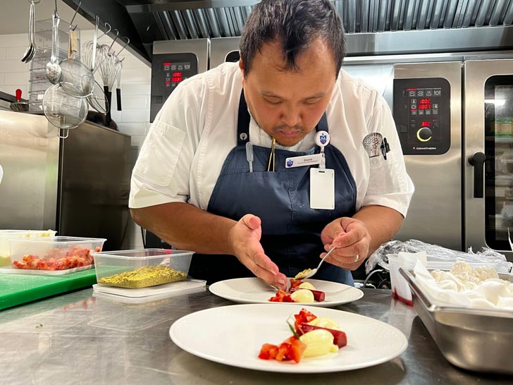 Chef David Martin plates a dish in a commercial kitchen