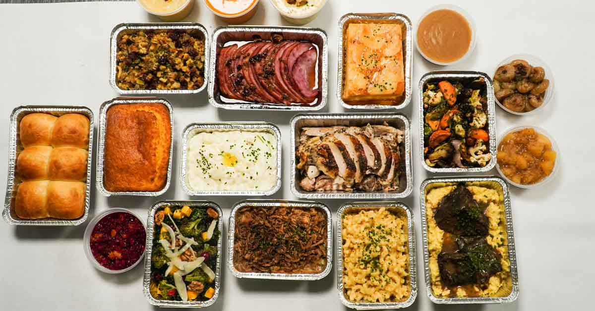 An aerial view of a spread of Thanksgiving food, all in foil containers