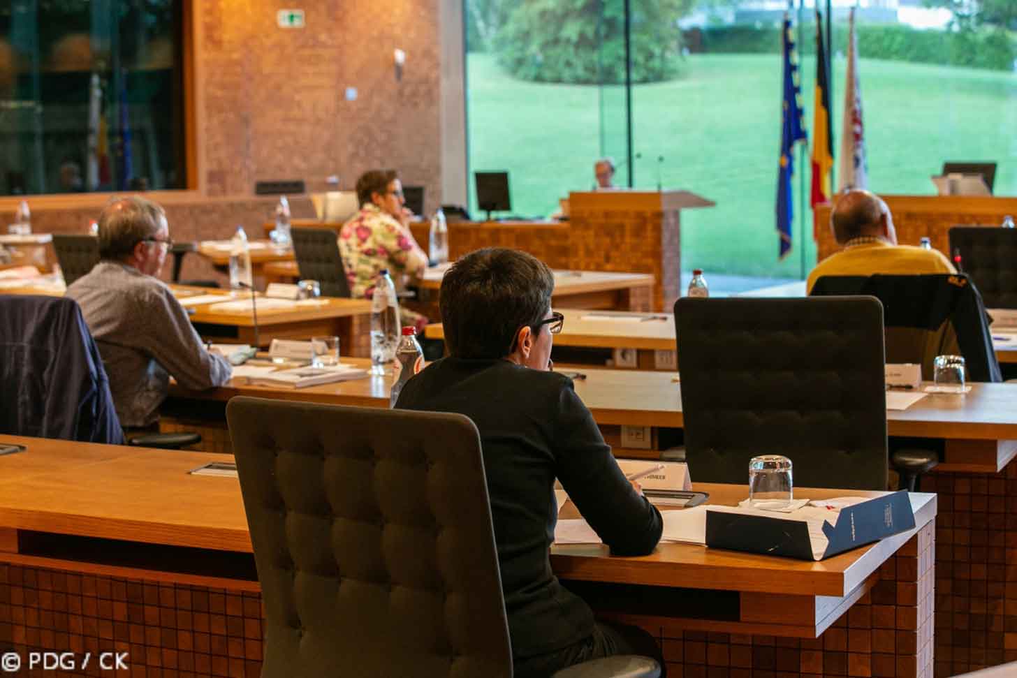 A person sits in an assembly meeting in Ostbelgien
