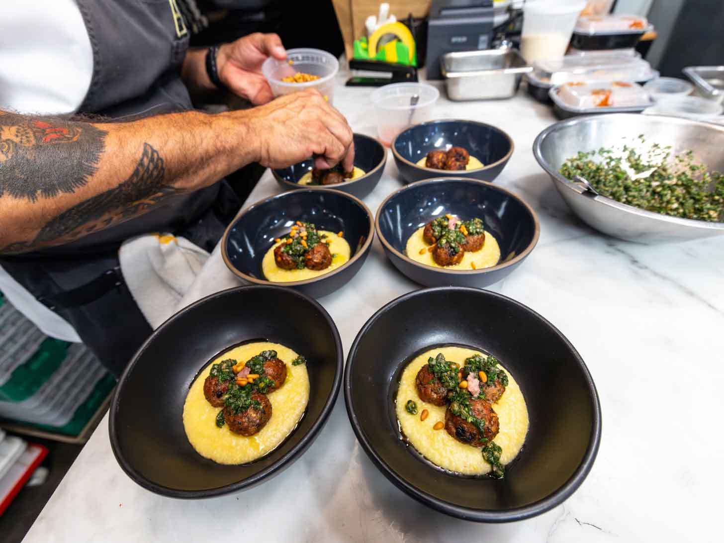 A chef plates meatballs made of culivated pork fat from Mission Barns