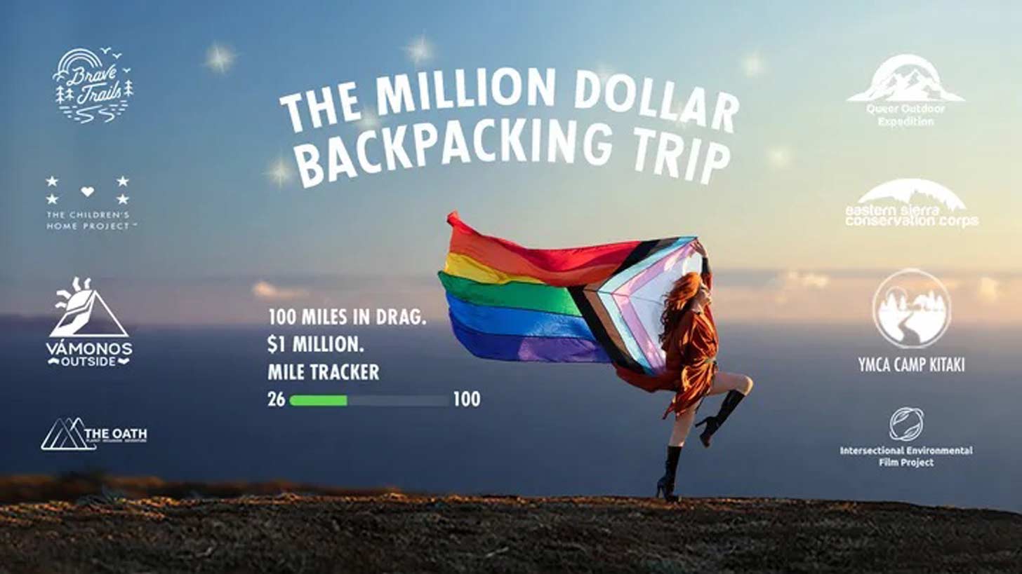 Drag queen Pattie Gonia in the outdoors,  holding a large Pride flag