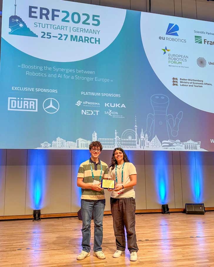 A boy and a girl accept an award at ERF2025