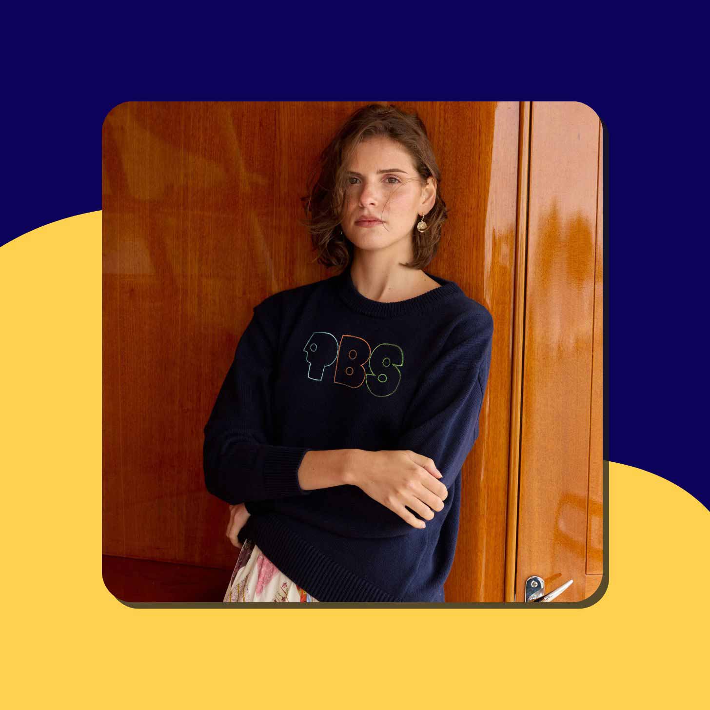 A woman in a navy blue PBS logo sweatshirt from Lingua Franca