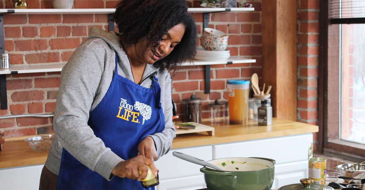 A woman, Shanette Merrick, teaches a virtual cooking class in a kitchen