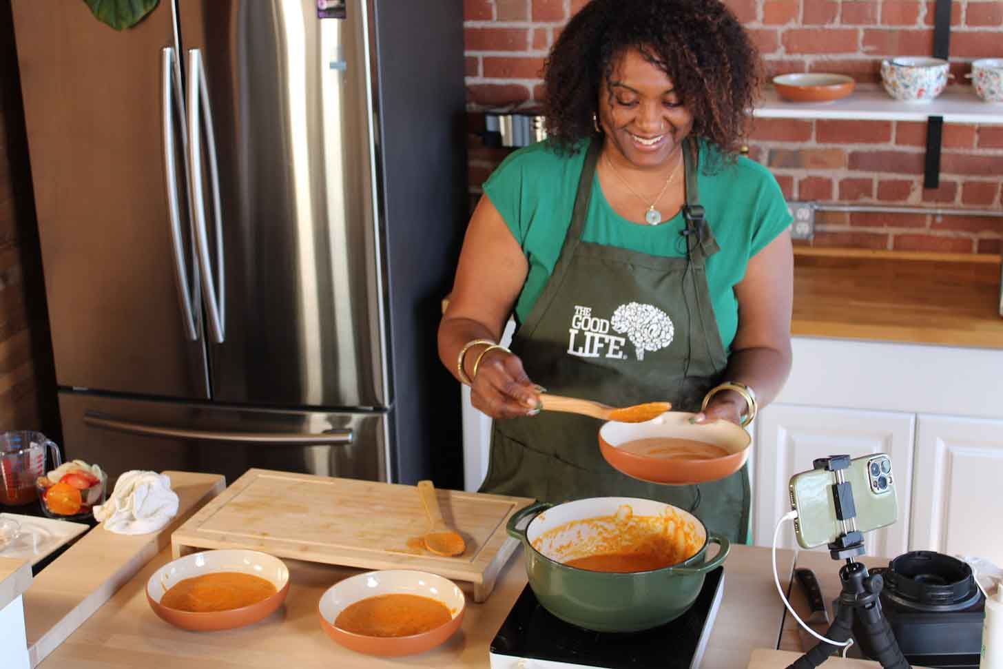 A woman, Shanette Merrick, teaches a virtual cooking class in a kitchen
