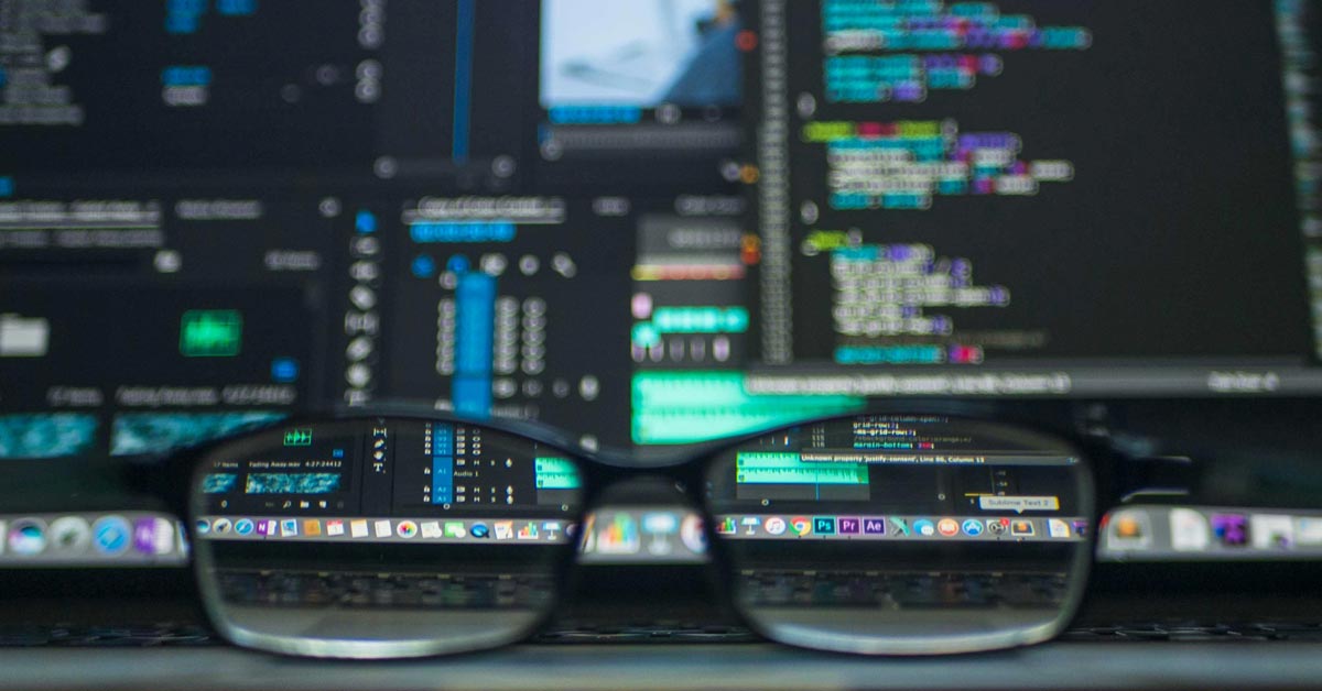 Glasses sit in front of a screen filled with code