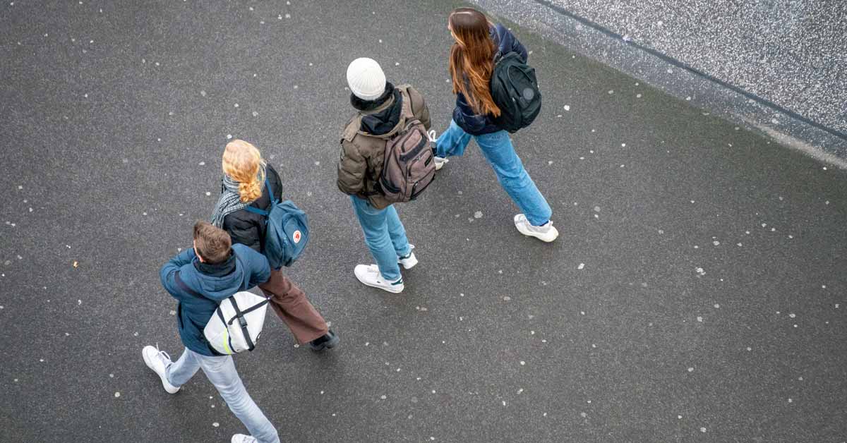 An aerial view of four teenagers walking in the street