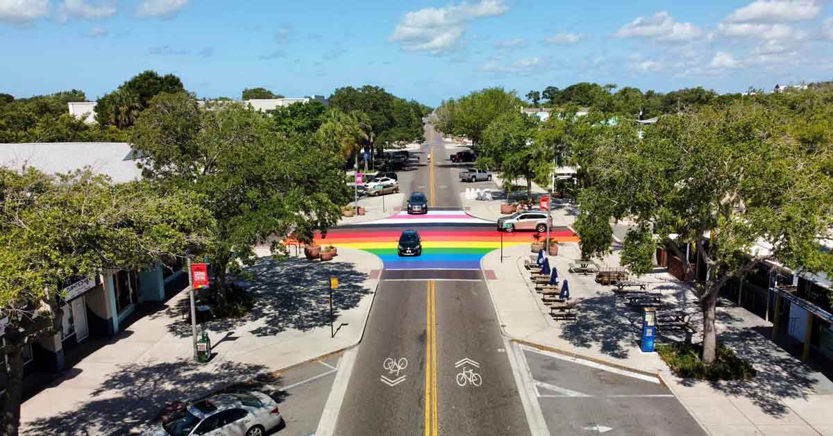A Progress Pride flag-colored crosswalk painted in a busy intersection in St. Petersburg, Florida