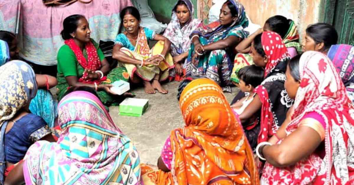 Sushma Devi (in green), a local woman trained in air quality mapping, demonstrates the use of an air quality monitor to women in Mahuda village, Dhanbad