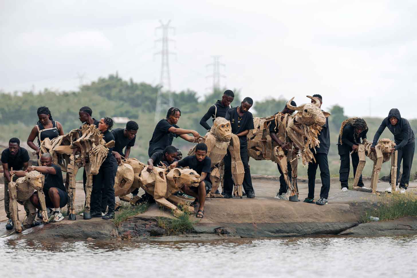A herd of giant cardboard animal puppets and human puppeteers in the Congo Basin