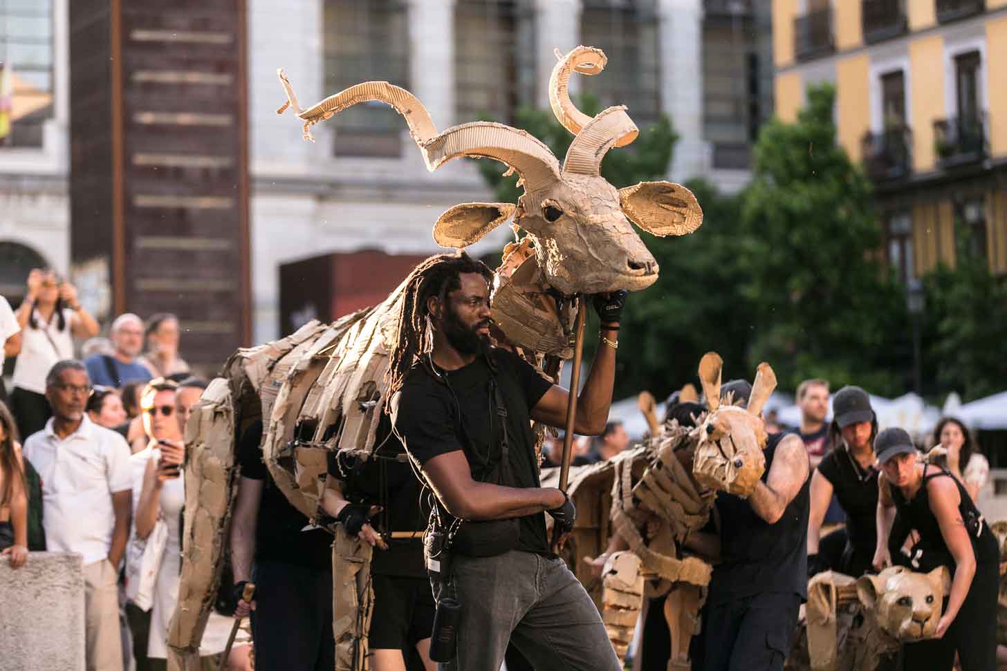 A puppeteer guides a large cardboard puppet of an pronghorned sheep